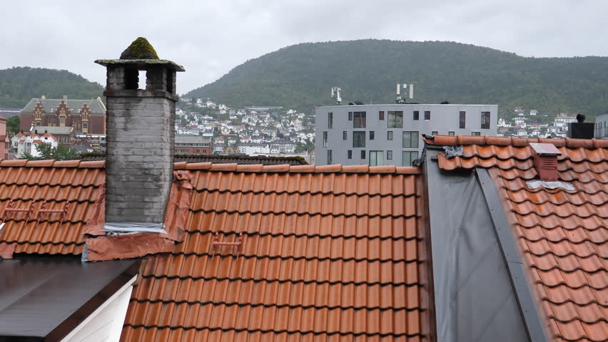 Old and modern house rooftops in Bergen, Norway. Elevated view, right pan.