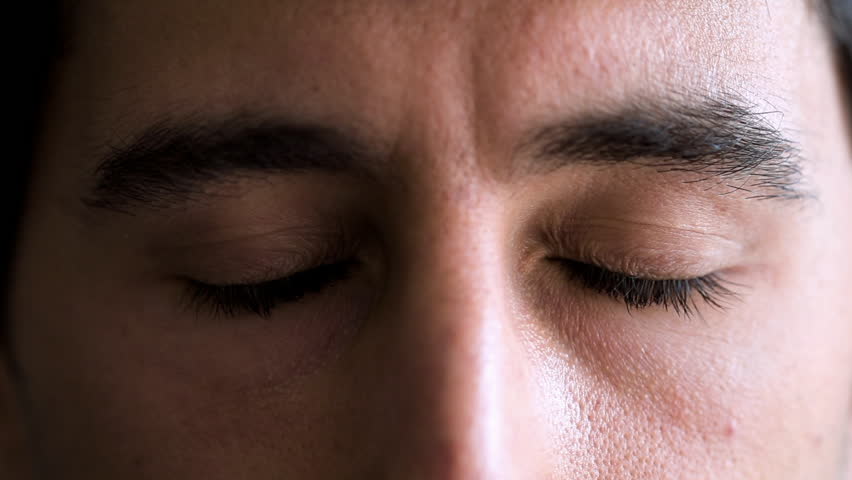 Man's eyes open wide in a close-up, showing a look of surprise or shock. His expression is intense and dramatic, highlighting an unexpected moment of realization or astonishment