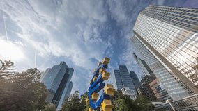 Timelapse hyperlapse of the Euro currency sign in downtown Frankfurt near the former headquarters of the European Central Bank. Sunlight flare reflects off skyscrapers amid a cloudy sky. Germany - Powered by Shutterstock - Get 15% off with code: PIKWIZARD15