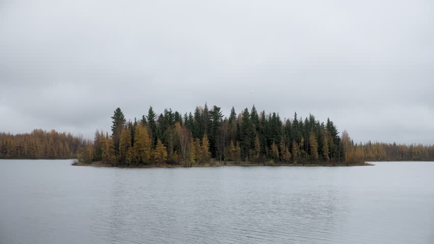 Chena Lake in Alaska with gorgeous fall colors on the trees, a peaceful forest covered island