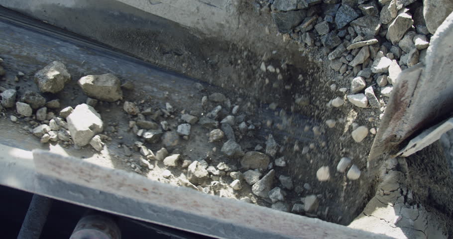 Rock crusher plant machine, line production in process, conveyor belt transport  crushed stone pieces on separation of building materials, close up