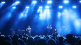 Live music event. Crowd at concert with raised hands and bright stage lights in background, - Powered by Shutterstock - Get 15% off with code: PIKWIZARD15