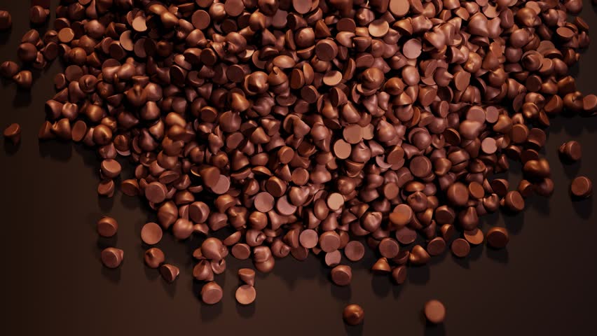 Dark chocolate chips spill out on the brown background. The backdrop for confectionery, candy shop. The pile of tiny cocoa candies. Delicious toppings for cookies or biscuits. Sweet temptation.