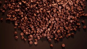 Dark chocolate chips spill out on the brown background. The backdrop for confectionery, candy shop. The pile of tiny cocoa candies. Delicious toppings for cookies or biscuits. Sweet temptation. - Powered by Shutterstock - Get 15% off with code: PIKWIZARD15