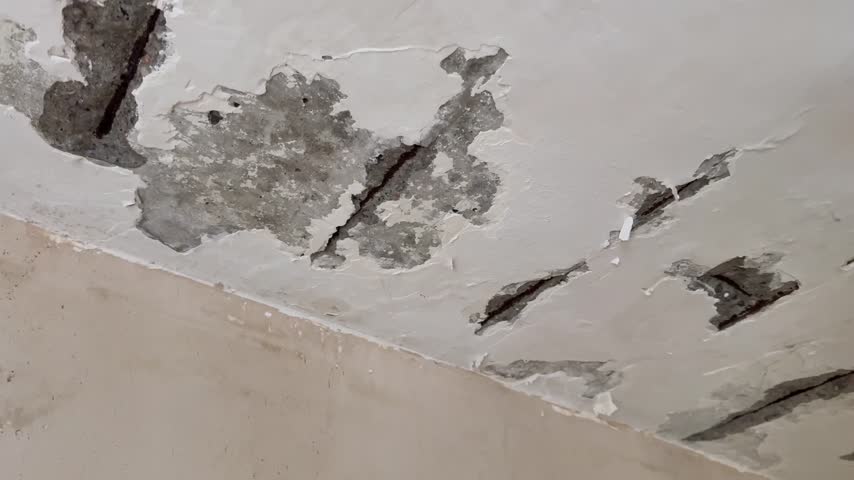 Close up view of worker scraping ceiling surface with spatula.Renovation concept.