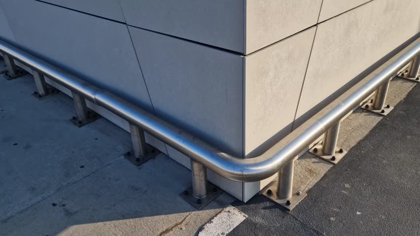 around the facade and columns of the underground garage is a metal bumper made of stainless steel pipes anchored to the ground with screws. frame tube attached to floor with four screws, pole