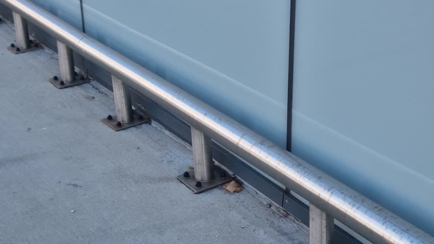 around the facade and columns of the underground garage is a metal bumper made of stainless steel pipes anchored to the ground with screws. frame tube attached to floor with four screws, pole