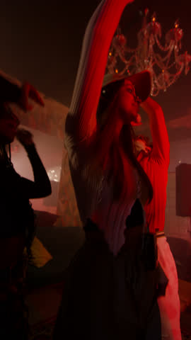 Vertical shot from below of group of diverse gen Z friends enjoying themselves on dance floor during club party