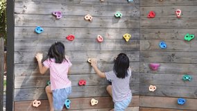 Children play outdoors on a wooden playground in a park. Happy girl playing on wooden climbing wall in playground during summer. - Powered by Shutterstock - Get 15% off with code: PIKWIZARD15