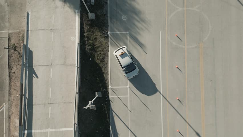 Aerial view of a car parallel parking in a driving test center. Vehicle driving training school.