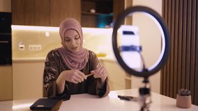 Arab woman in traditional abaya dress and headscarf recording video on phone - Powered by Shutterstock - Get 15% off with code: PIKWIZARD15