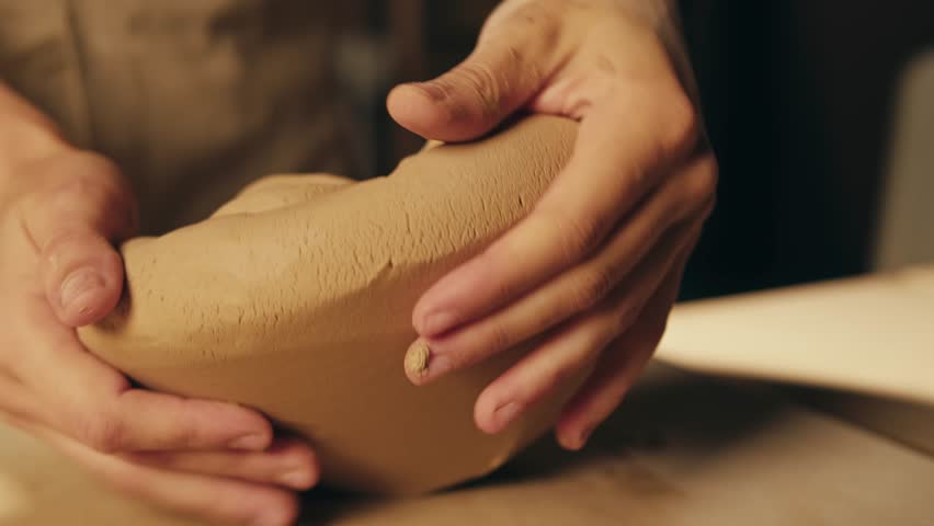Man potter works with clay on master class in studio. Working process in ceramic workshop. Potter making vase on pottery wheel. Handmade concept. 