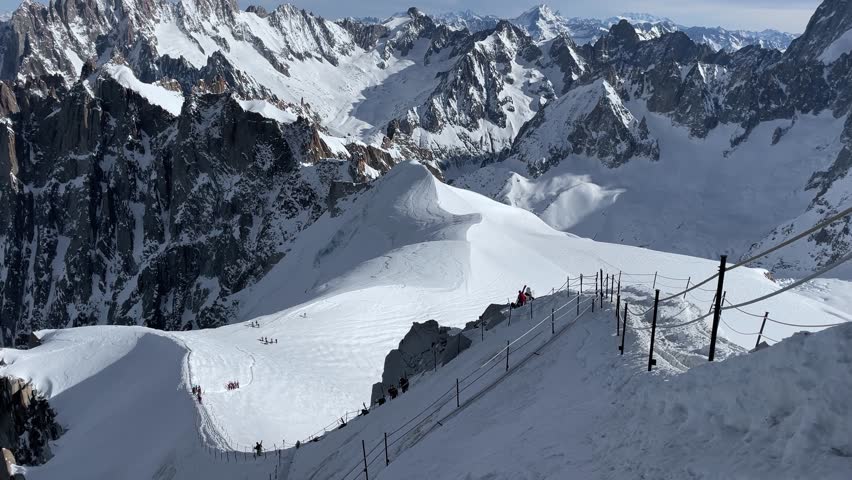 A group of freeride skiers and snowboarders are going down a snowy slope in the Alps Chamonix Mont Blanc mountains of France to a rally point in winter