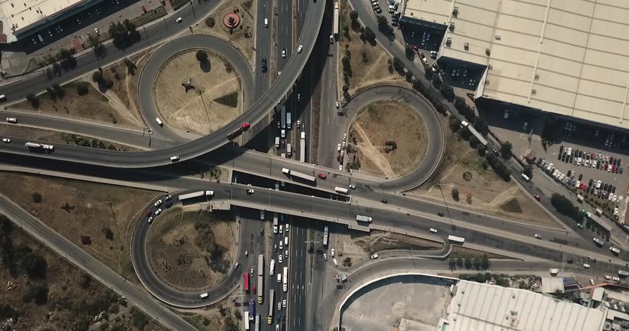 Road interchange on the Mexico-Querétaro highway providing entry and exit to Mexico City, with cars, trucks, and public transportation circulating in Tepotzotlan area