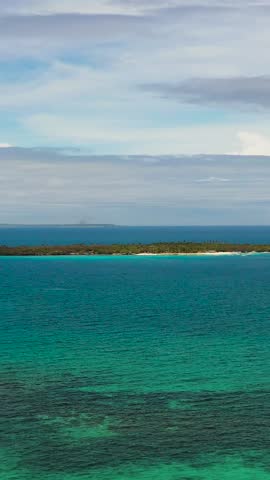 Virgin Island surrounded by blue sea and coral reefs. Blue sky and clouds. Bantayan, Cebu. Philippines. Vertical view.