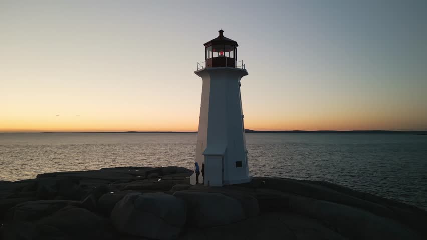Stunning Cinematic Drone Shot Of Peggys Cove Lighthouse On The Rocky Shores Of The Atlantic, Captured As The Sun Sets Over The Beautiful Coastline Of Nova Scotia, Canada.