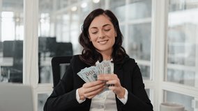 Happy businesswoman showing money, cash, hundreds of dollars, smiling at the camera, success, investment, finance. Business, office, work, job. - Powered by Shutterstock - Get 15% off with code: PIKWIZARD15