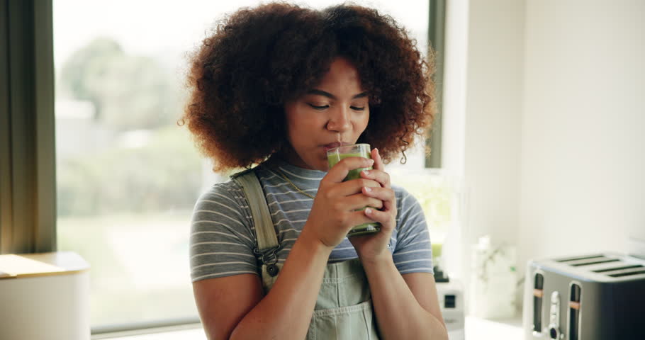 Smoothie, happy and drink with woman in kitchen for detox, nutrition and protein shake. Green juice, weight loss and wellness with person and glass in home for vegan diet, health or breakfast
