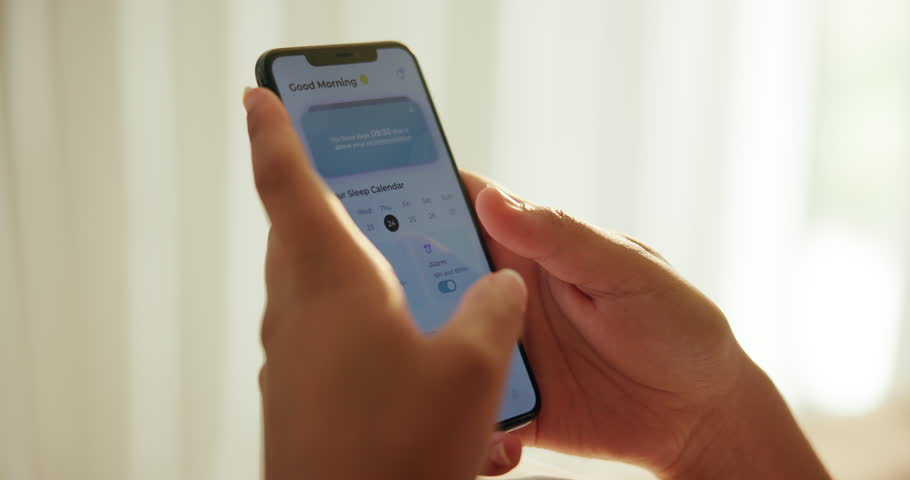Hands, person and phone with screen in home for internet app to track sleeping patterns and analyze movement. Tech, digital program and checking smartphone in morning for resting analytics or wake up