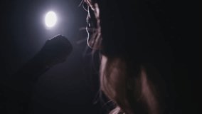 Close-up of the face of the singer with microphone on a black smoky background. The singer sings a song on stage in the dark, smoke, purple light, concert. - Powered by Shutterstock - Get 15% off with code: PIKWIZARD15