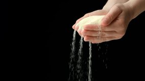 Hands pouring dry semolina durum flour, black background, copy space for text, slow motion - Powered by Shutterstock - Get 15% off with code: PIKWIZARD15