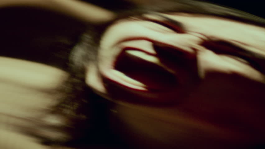 Contorted reflection in distorting mirror of emotional man screaming in dark room, conveying raw emotion - pain or rage