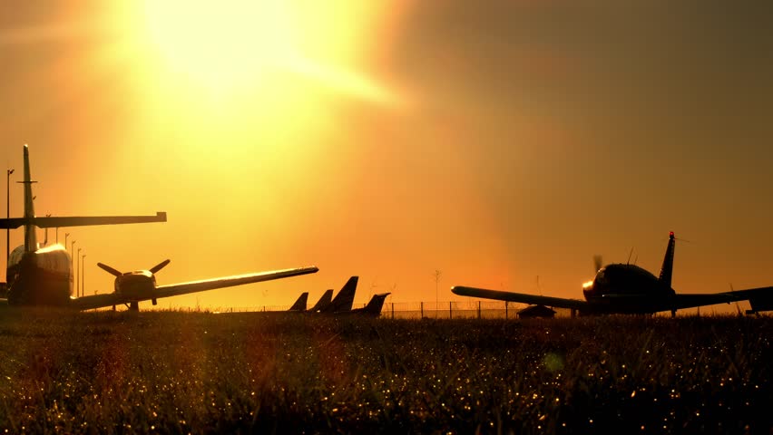 Turboprop airplanes silhouette on the apron of an airport during sunset or sunrise or dawn. Single engine lightweight aircraft taxiing for take off or after landing