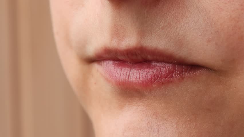 Woman eating a takeaway fried chicken wing from fast food cafe with a mouth and teeth close up
