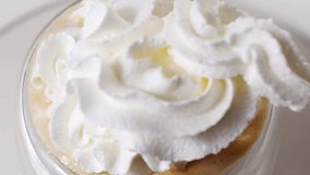 Whipped cream is squeezed out of a can onto a rotating cup of coffee. preparation of delicious invigorating and dessert drinks. - Powered by Shutterstock - Get 15% off with code: PIKWIZARD15