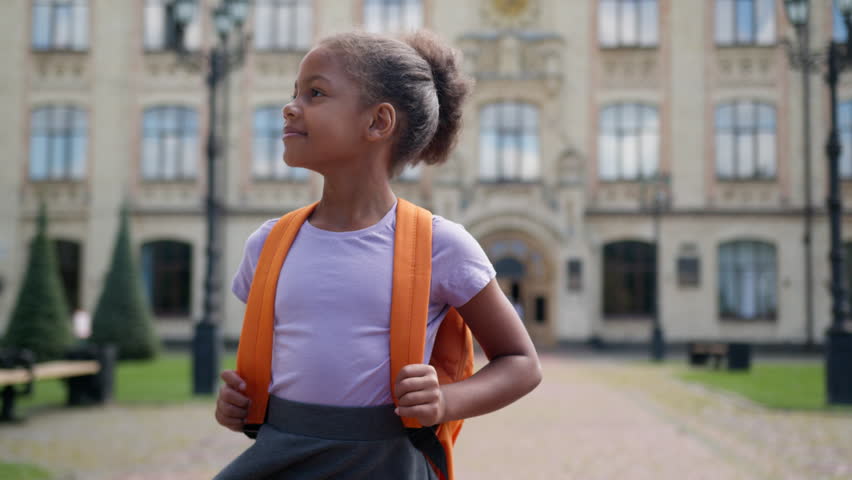 Elementary education happy little girl African American kid daughter female child learner pupil student beginner schoolgirl class studying walking going from school outdoors city walk smile at camera