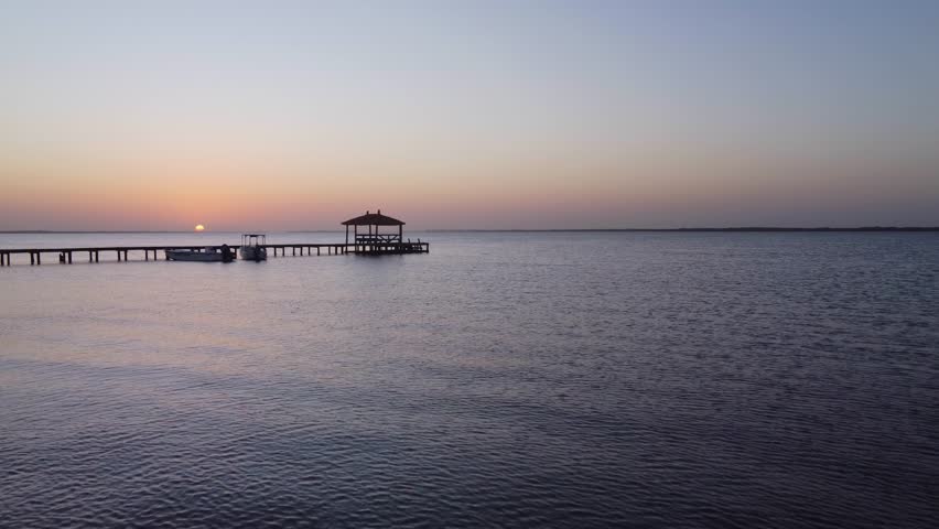 Idyllic walk with wooden planks and a hut on a lake in Senegal at sunset