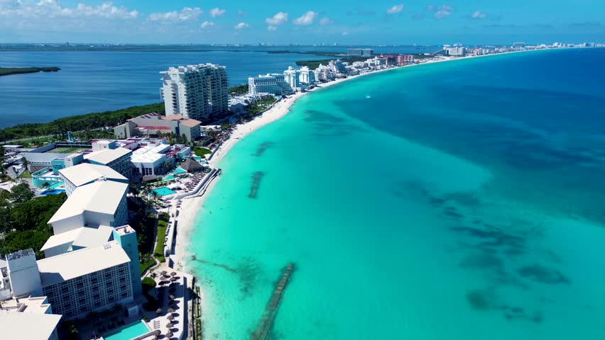 Drone aerial landscape coastline of Cancun with hotel resort swimming pool apartment units on beach with lagoon lake Mexico Playa Marlín Central America travel tourism