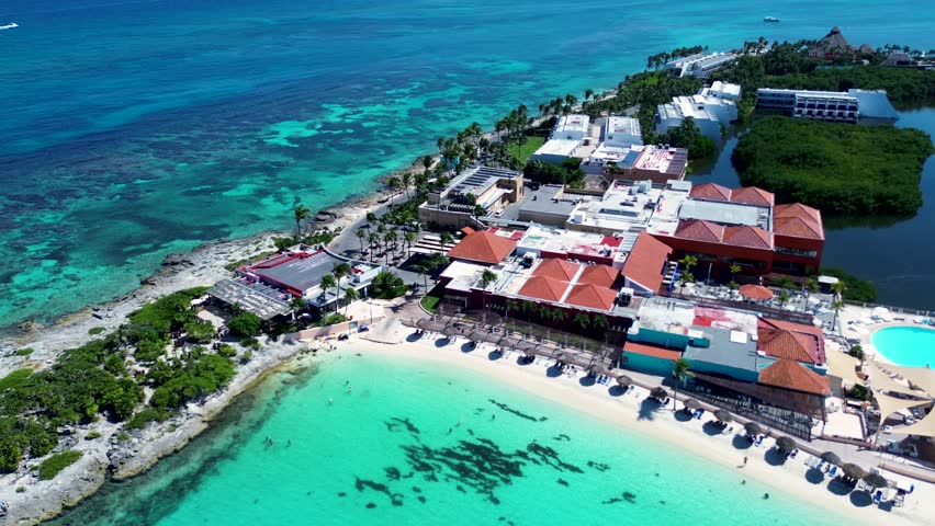 Drone aerial landscape of coastline point headland in Cancun with hotel resorts beach umbrellas restaurants Caribbean Sea Ocean reef snorkelling Mexico vacation holidays travel