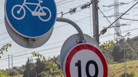 Bicycle sign and a speed limit sign are standing in an urban environment, suggesting a focus on sustainable transportation and eco friendly commuting options - Powered by Shutterstock - Get 15% off with code: PIKWIZARD15