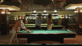 Full shot of group of diverse male and female friends gathered in night bar to play pool billiard together - Powered by Shutterstock - Get 15% off with code: PIKWIZARD15