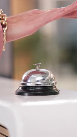 Person, hand and ring bell at hotel reception for customer service, hospitality and help. Closeup, front desk and arrival at lodge as visitor or client for accommodation, reservation and booking