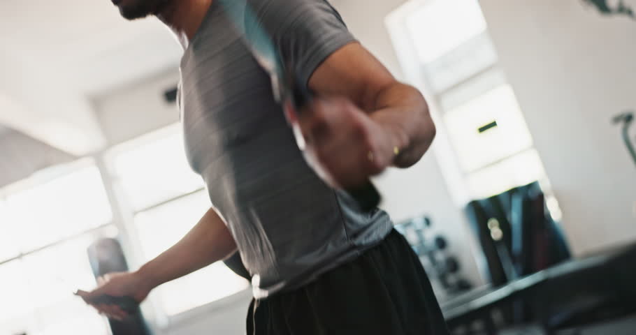 Hands, skipping rope or man jumping in gym with fitness for body, training and cardio exercise in challenge. Action, agility movement or motion of athlete with wellness, mobility workout or energy