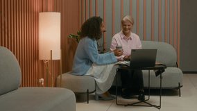 Diverse team of three creative professionals cooperating on project in sleek design office space, sitting by laptop, all involved in discussion - Powered by Shutterstock - Get 15% off with code: PIKWIZARD15