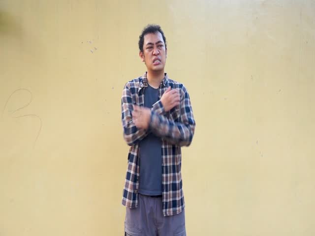 Footage of Asian man holding his shoulder feel pain, show illness gesture on yellow background