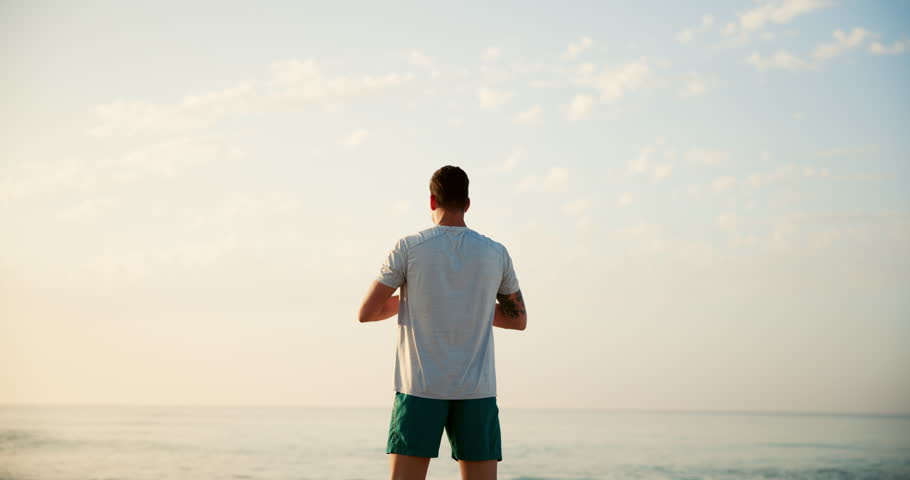 Man, yoga and stretching with back on beach for breathing exercise, fitness or outdoor workout in nature. Male person, yogi or zen with warm up or sky for balance, health and wellness on ocean coast
