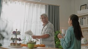 attractive asian senior couple standing at white cozy kitchen, drinking fresh morning coffee together, enjoying good morning - Powered by Shutterstock - Get 15% off with code: PIKWIZARD15