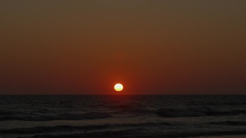 Majestic sunset over calm ocean waves in Blavand, Denmark. Perfect for tranquil nature scenes or travel promotions.