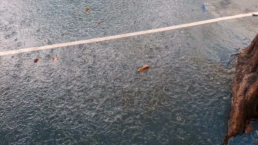 Blurred video background of rain falling in a school field, heavy rain, raindrops, rainy season, tropical countries