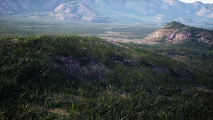 Landscape With Rolling Hills And Majestic Mountains In The Distance 