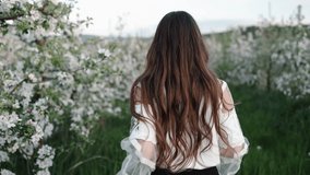 Turning around, Happy woman, Blooming orchard. Woman, smiling and glancing back, runs through blooming orchard filled with green grass and flowering trees. - Powered by Shutterstock - Get 15% off with code: PIKWIZARD15