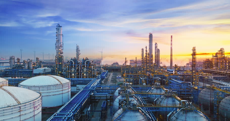 Petrochemical plant industrial buildings and complex piping equipment in industrial area at sunset