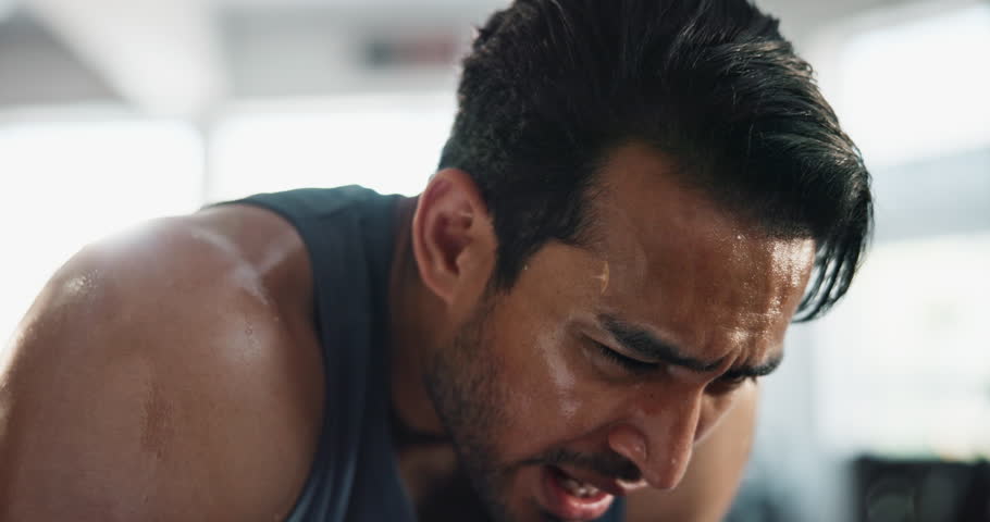Man, breathing and sweat in gym for fitness, exercise and break with challenge, cardio and workout. Male person, training and tired in sports club for fatigue, recovery and health with muscle growth