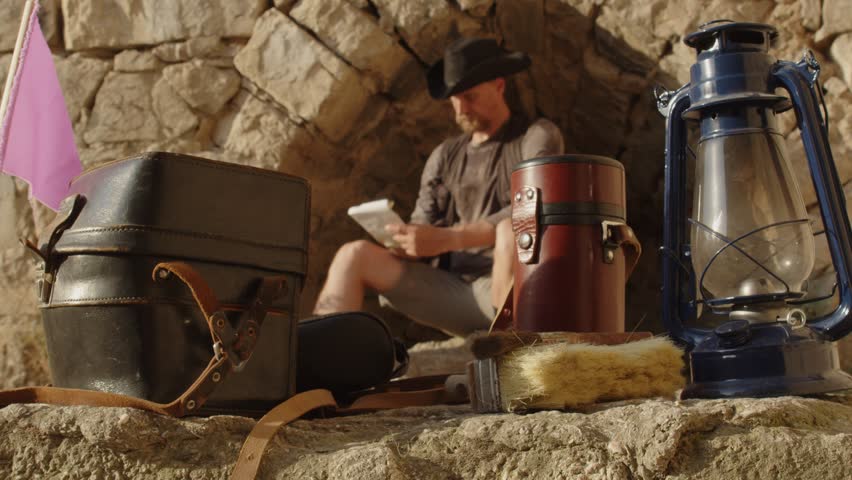 Excavation equipment close up against the backdrop of an archaeologist at work in blur. School project. Historical reconstruction of an archaeological expedition of the mid-19th century for the blog