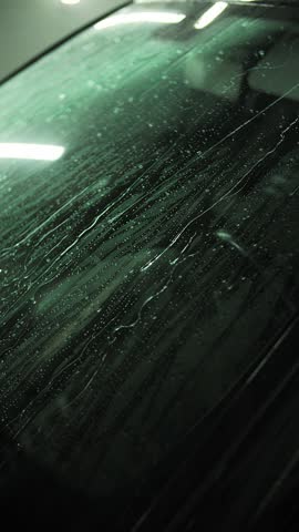 Rinsing the automobile with water at a car wash