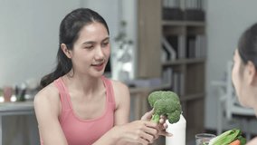 Nutritionist holding broccoli explains the benefits of healthy food to a client, emphasizing the importance of a balanced diet and nutritious eating for overall wellness - Powered by Shutterstock - Get 15% off with code: PIKWIZARD15